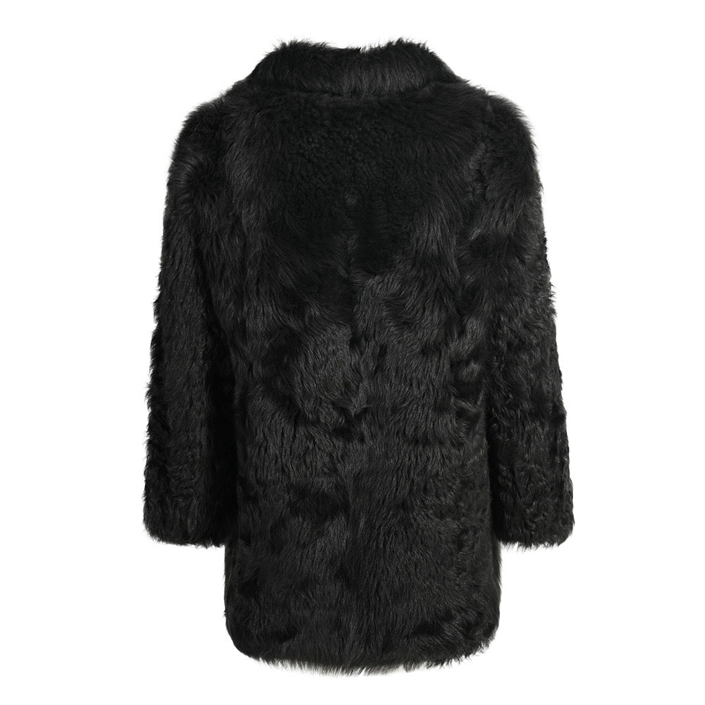 Plush black shearling coat tailored to flatter fuller figures, combining classic style with thick, warm fabric ideal for colder weather.