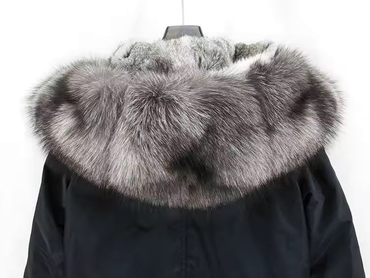 Close-up of the fox fur hood trim on a black technical parka, displaying soft, voluminous fur and precision stitching for luxurious insulation.