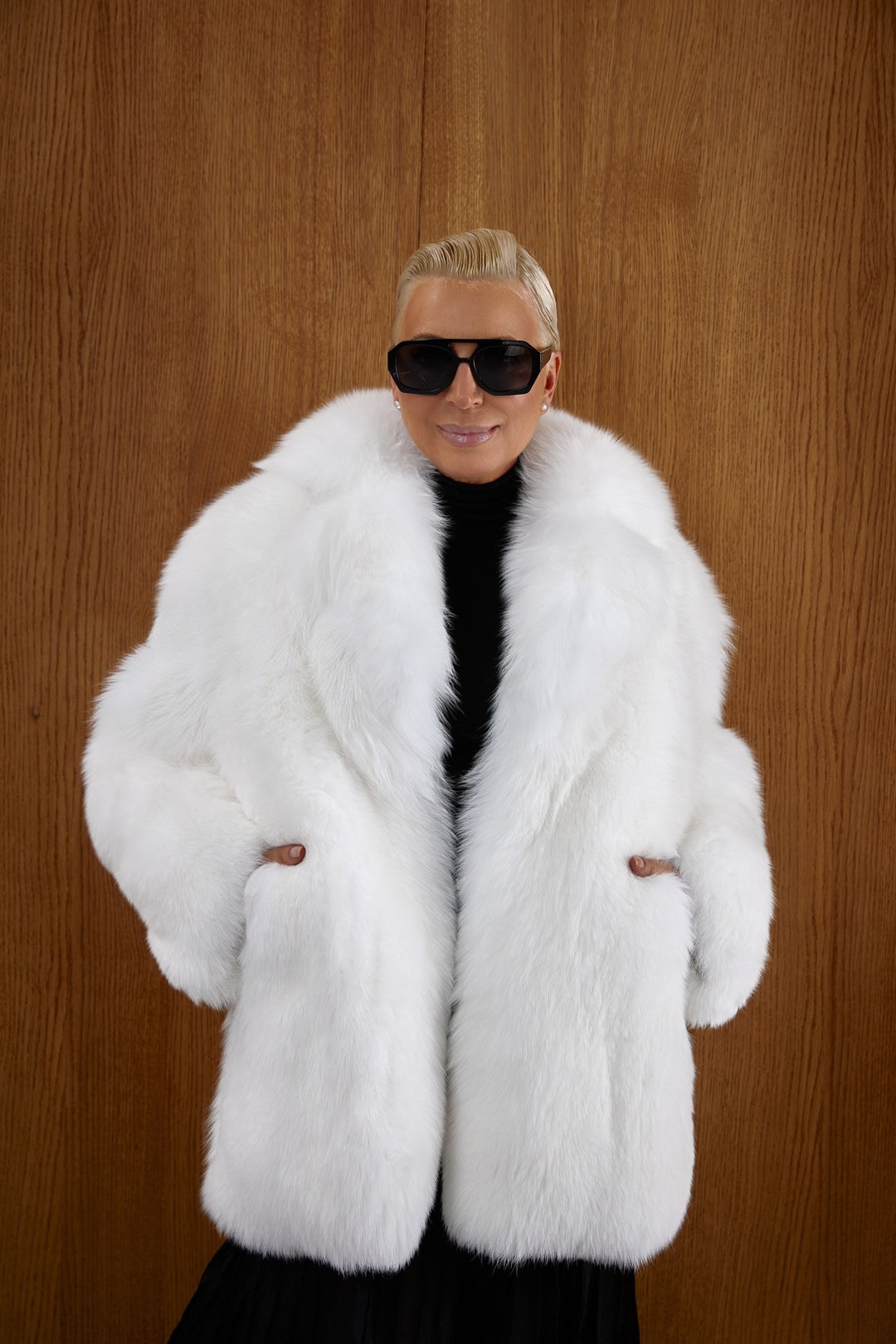 A woman wearing a luxurious pure white fox fur coat with a double-breasted neckline, showcasing its voluminous texture and elegant silhouette, perfect for extreme winter weather.